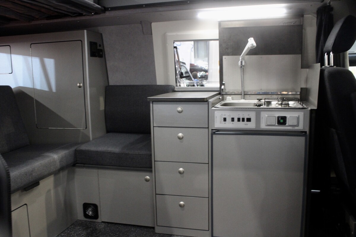 Werz fills its Magnum B interior out a little differently, with a compact wraparound sofa, tall drawer console and compact kitchen block