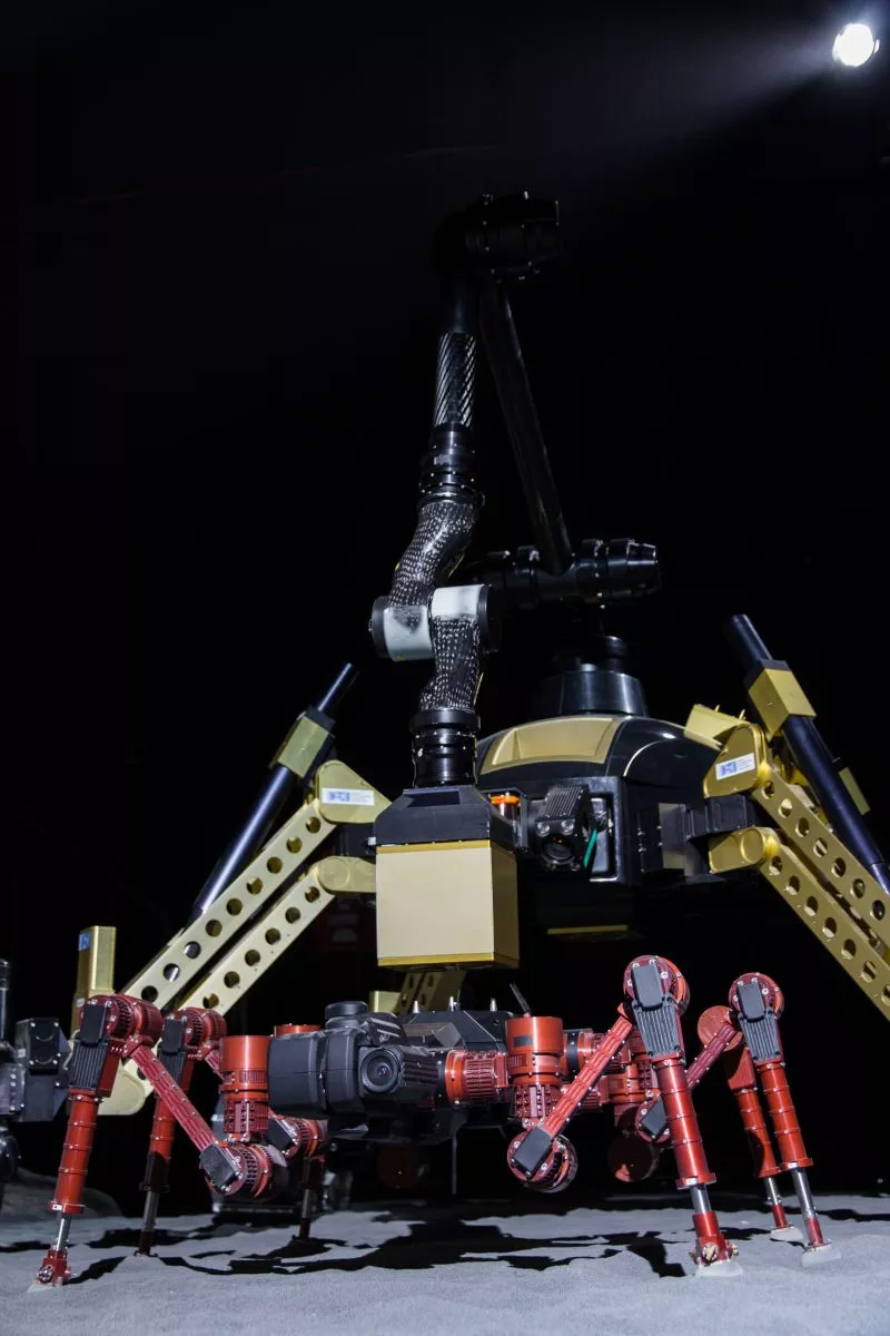 SHERPA is using its manipulator arm to equip CREX with an additional payload-item