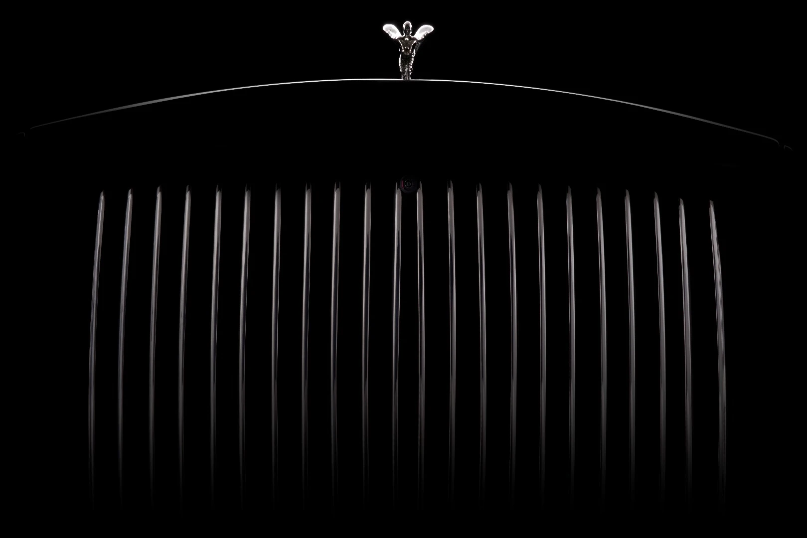 The wings on the Spirit of Ecstasy stand out against a dark background