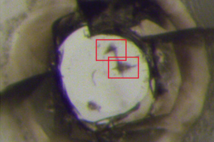 An image of one of the diamond anvils under an optical microscope; one of the super-hard C3N4 polymorph samples indented the anvils' surface