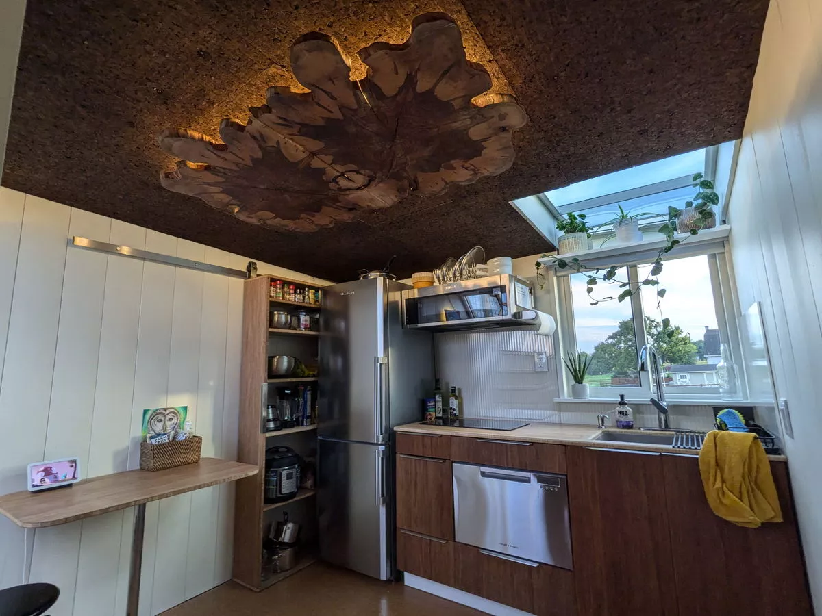 Unusually, the kitchen is located upstairs and it has a feature ceiling made of cork and wood