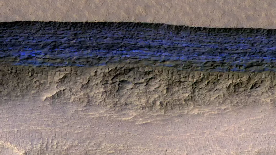 The blue section (artificially colored) represents the exposed face of an underground ice sheet on Mars, at a scale of about 500 m (1,650 ft) wide