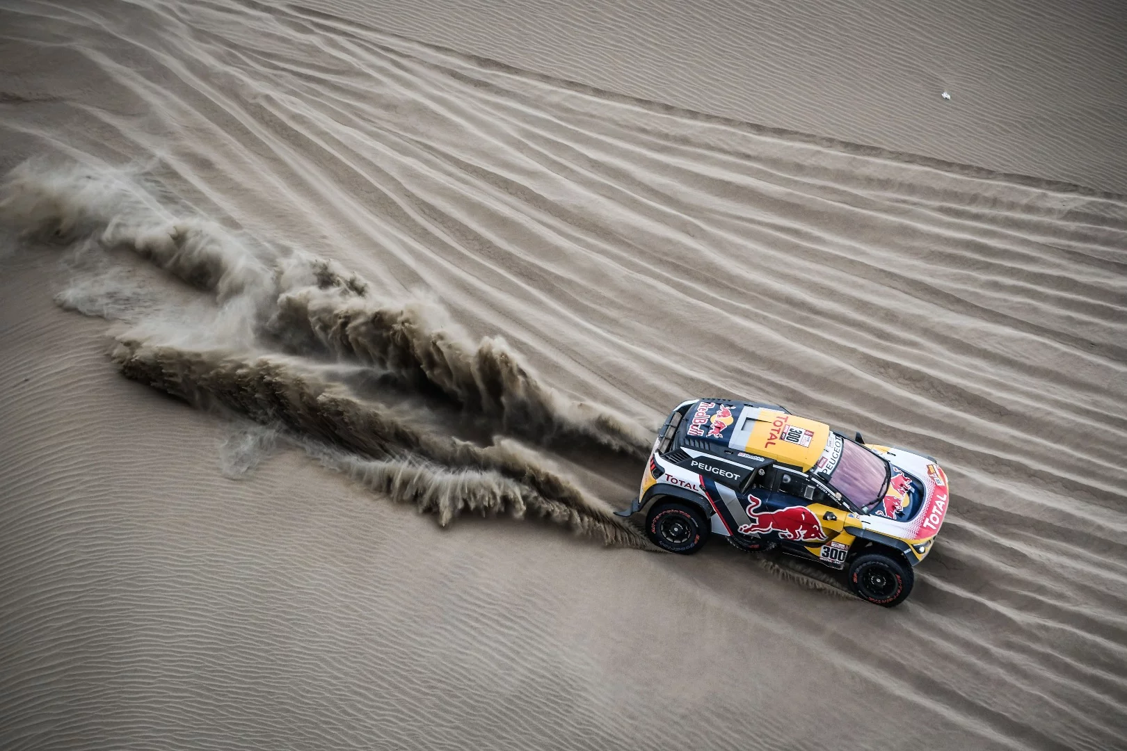 The Peugeot car of 13-times champion Stephane "Mr. Dakar" Peterhansel and Jean-Paul Cottret carves through well-worn sand. Peterhansel would eventually fail to finish after crashing into a tree, thoroughly in contention for a 14th win. This may be his last Dakar