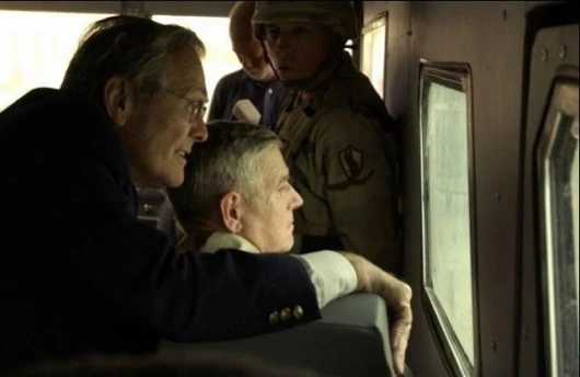 Donald Rumsfeld takes a keen interest in the secenery of beautiful downtown Baghdad.