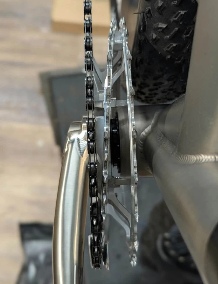 A ramping mechanism allows the chain to travel from one chainring to the other