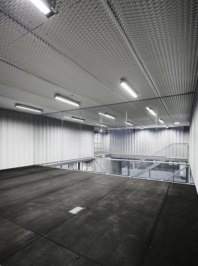 "The span between the containers is utilized as flexible spaces for primary workspace functions," explains Arcgency, concerning the design