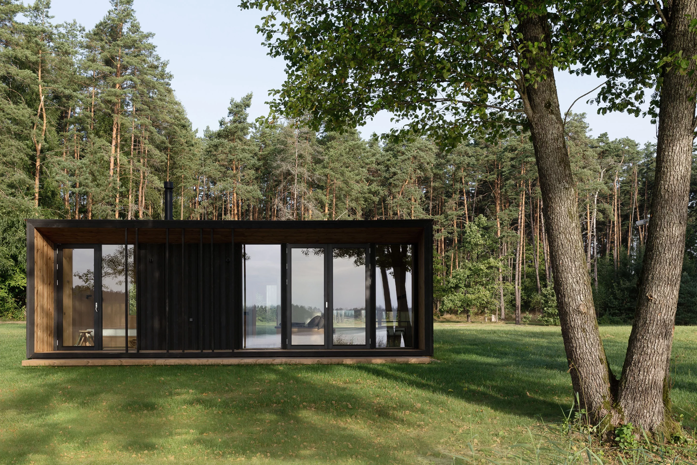 The Konga off-grid cabin features generous glazing on its front-facing side, filling the interior with natural light