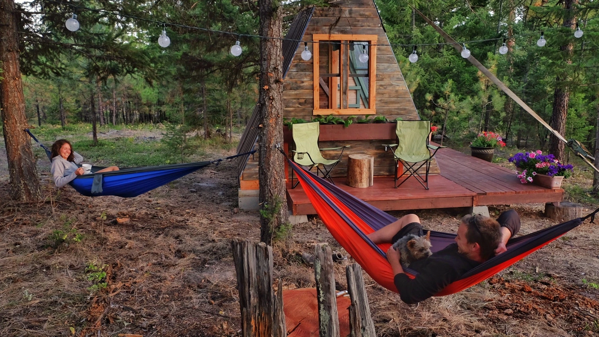 The exterior of the cabin includes chairs and hammocks