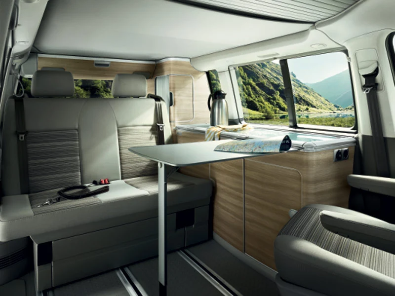 The vans come with pop-up roof, a kitchen area with fridge, burner cooker and sink, blinds for privacy, integrated LED lighting, and an awning with table and chairs