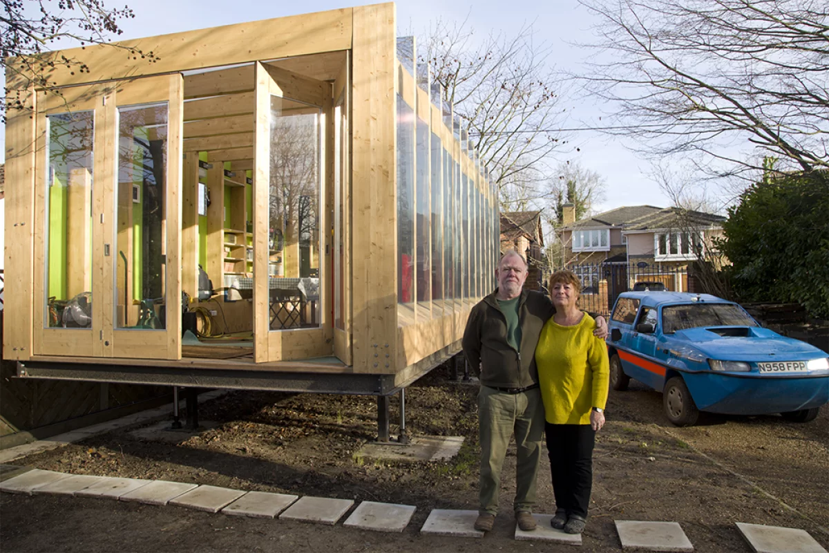 Erica and Peter in front of their flood-proof greenhouse and amphibious car