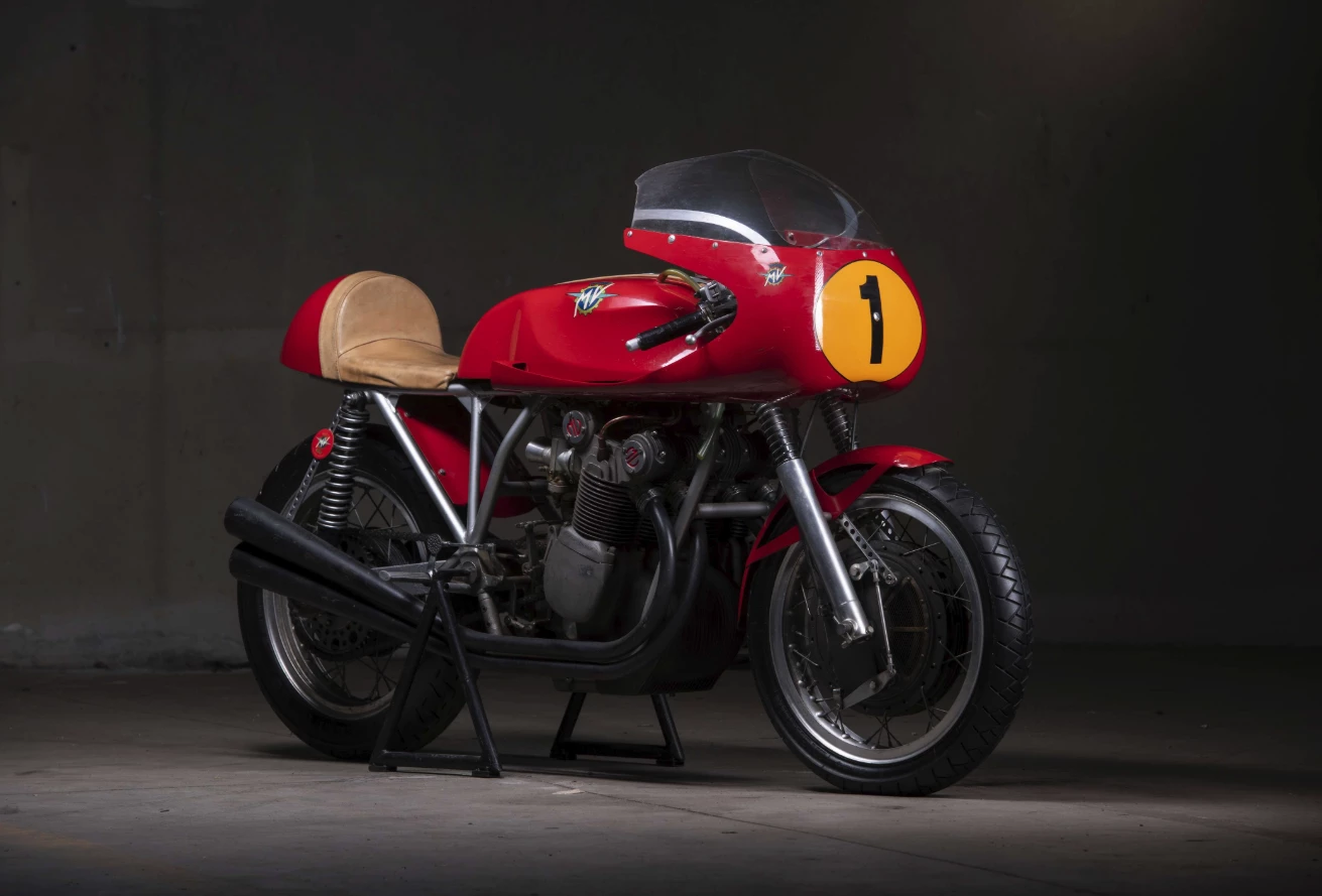 1972 MV Agusta 750 S John Surtees Tribute | Perhaps the most interesting of the six MV Agusta 750 S bikes available at Retromobile this year is this John Surtees tribute bike which is based on a 750 S motor and frame, and is believed to have been one of five constructed by legendary MV Agusta race engineer Arturo Magni. It incorporates Magni's proprietary chain drive conversion, a 300 mm Fontana drum brake, 48 mm Marzocchi forks and four Dell'Orto SSI 29 carburetors. It is no longer a road bike, as all lights and registration requirements have been removed in the construction, but is still estimated to fetch close to the current record auction price for a 750 S at €75,000 to €120,000.
