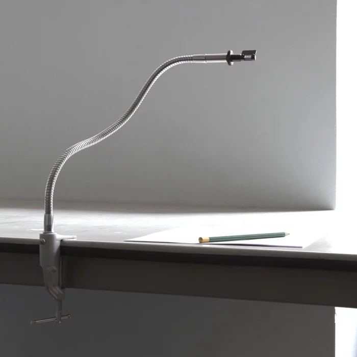 The NeoLucida's eyepiece is pointed toward the subject and extended over the paper on a goose-neck mount, which is simply clamped to one edge of the easel