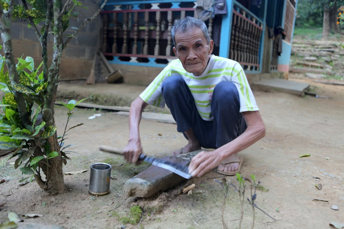 Don't let the clothes fool you. Cheap clothing manufactured in factories across Asia costs a negligible amount in comparison to the prices we pay for the same clothing in western countries. Everything else that's done around here has been going on for hundreds, maybe thousands of years. Here one of the villagers sharpens a machette.