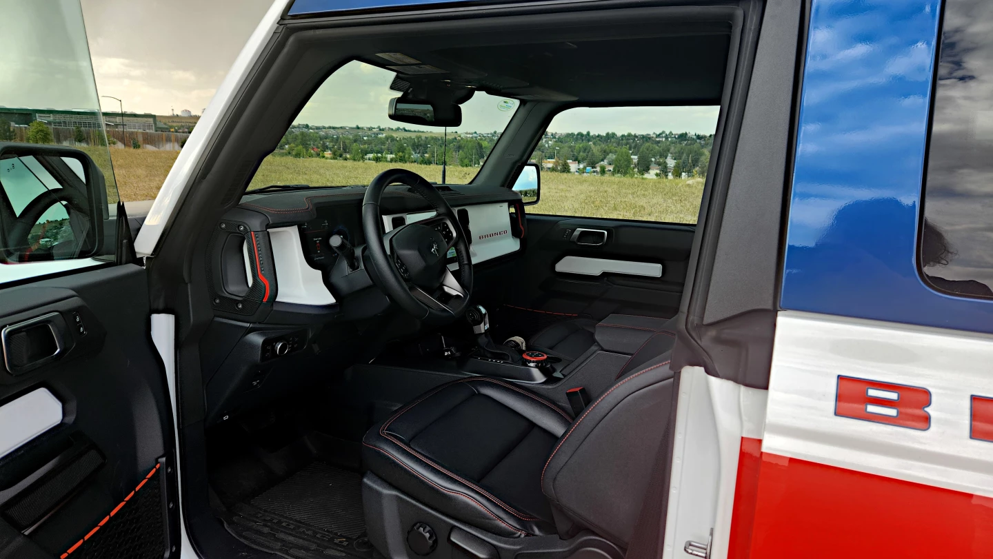 A few throwback designs like red stitching and white paneling compete with modern amenities in the 2025 Ford Bronco Stroppe