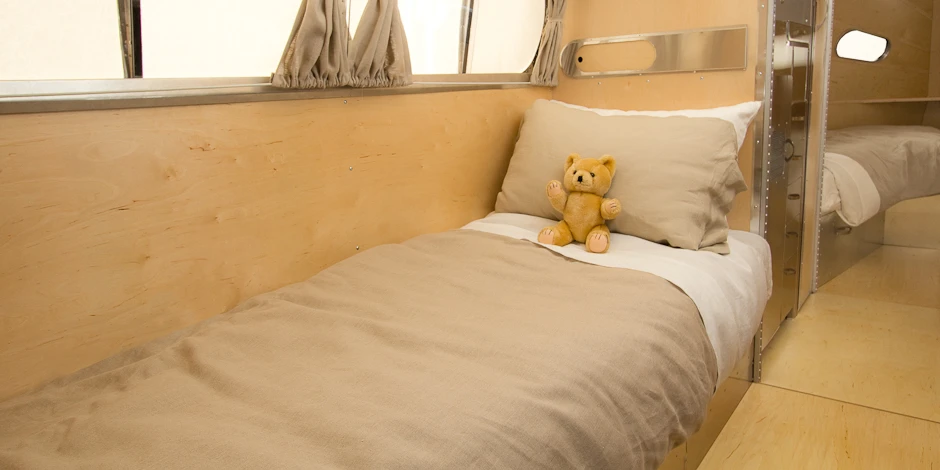 The Bowlus Road Chief interior is sheathed in aluminum and birch with a full-sized sofa and two armchairs that convert into twin beds