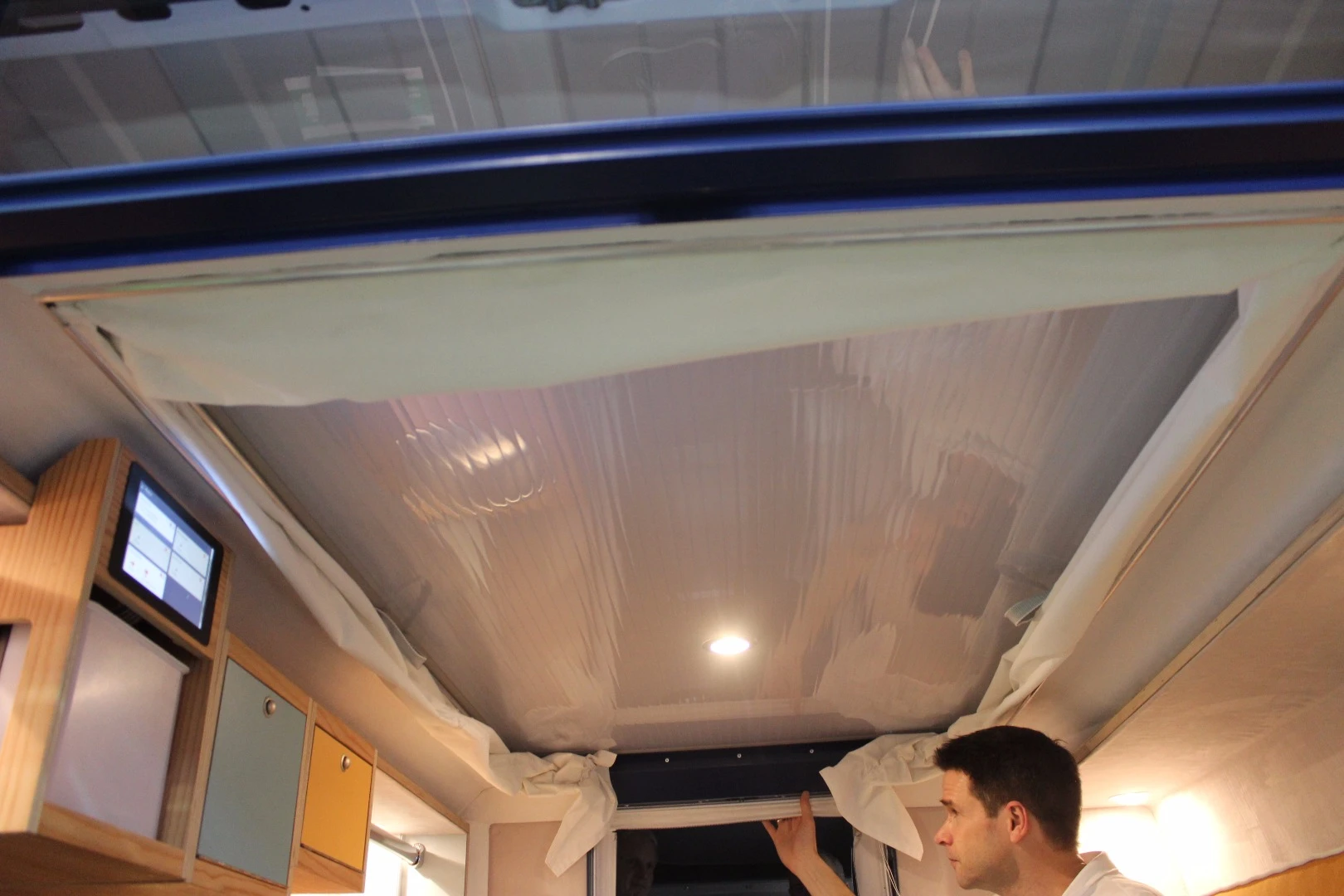Kortmann demonstrates how the ceiling pulls right down when it's time to break the PlugVan down and remove it from the van