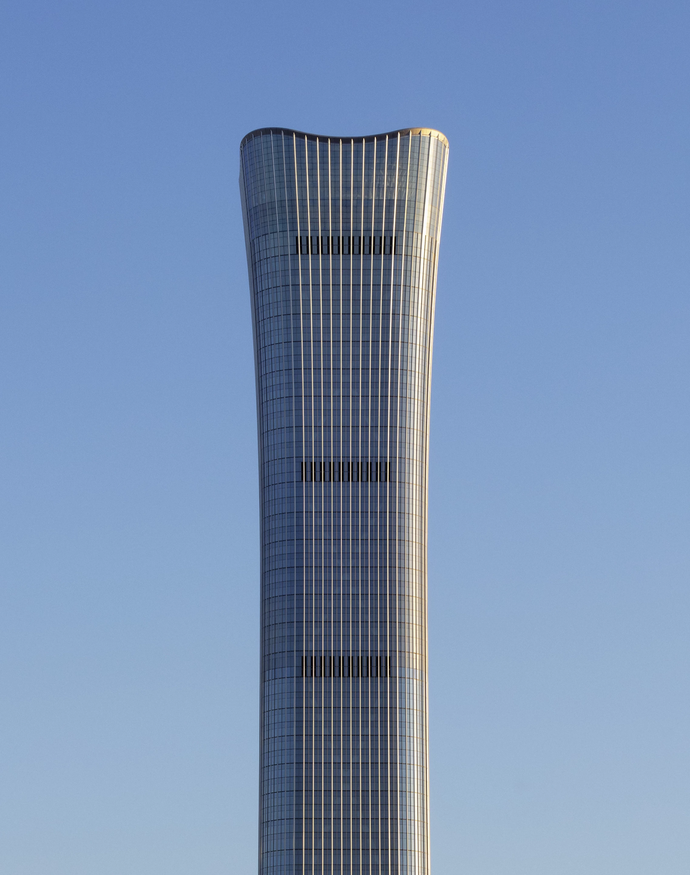 CITIC Tower's form widens at its top, which is unusual for a supertall skyscraper, due to the heavy wind loads at such great heights