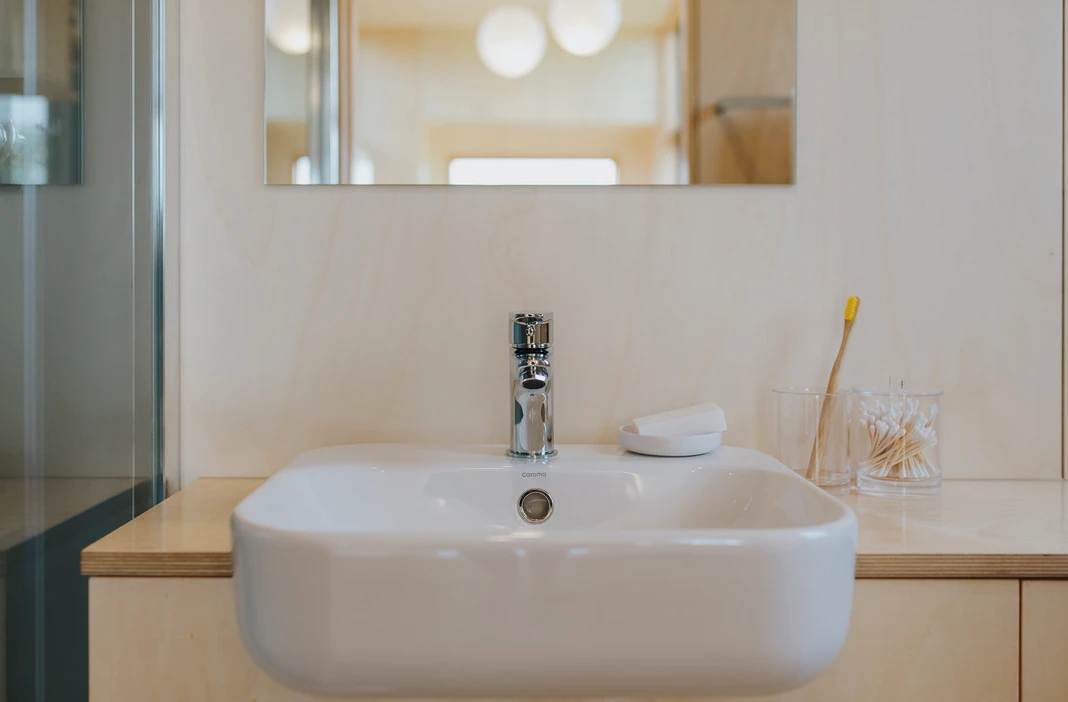 The First Light Tiny House's bathroom includes a sink, shower, and composting toilet