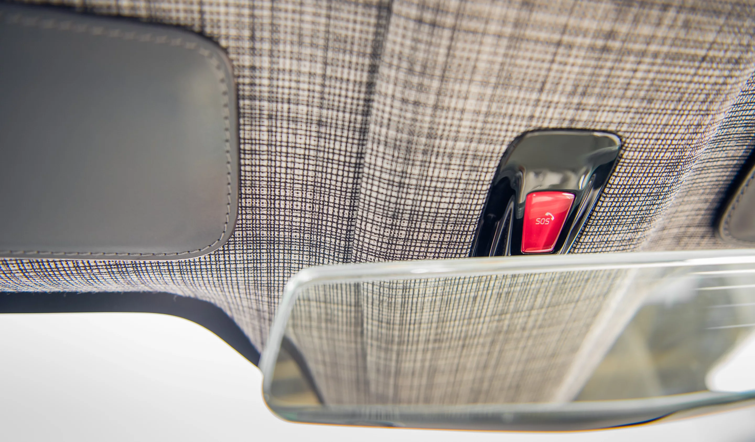 Checkered black and white wool on headliners and seat sides, plus orange seatbelts are clear signs of the retro Scandinavian design influence