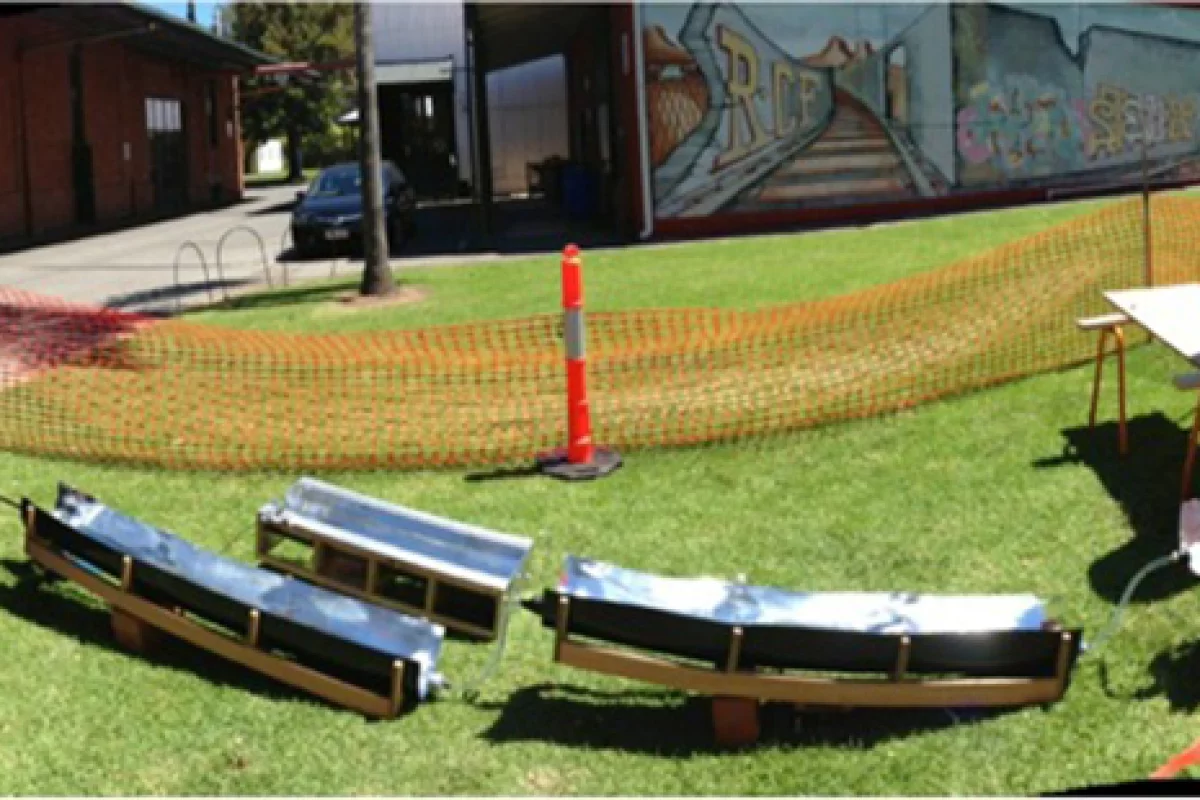 The water runs through a piece of piping, which rests in a trench-shaped structure coated in reflective metal