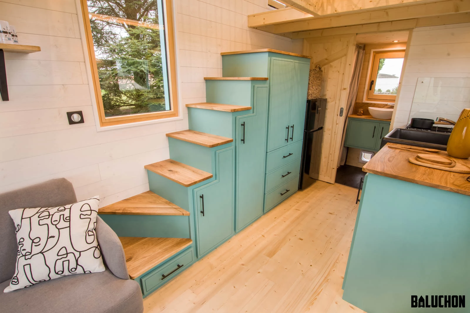 The Tiny house Kalzennig features a storage-integrated staircase, which provides access to the loft-based bedrooms
