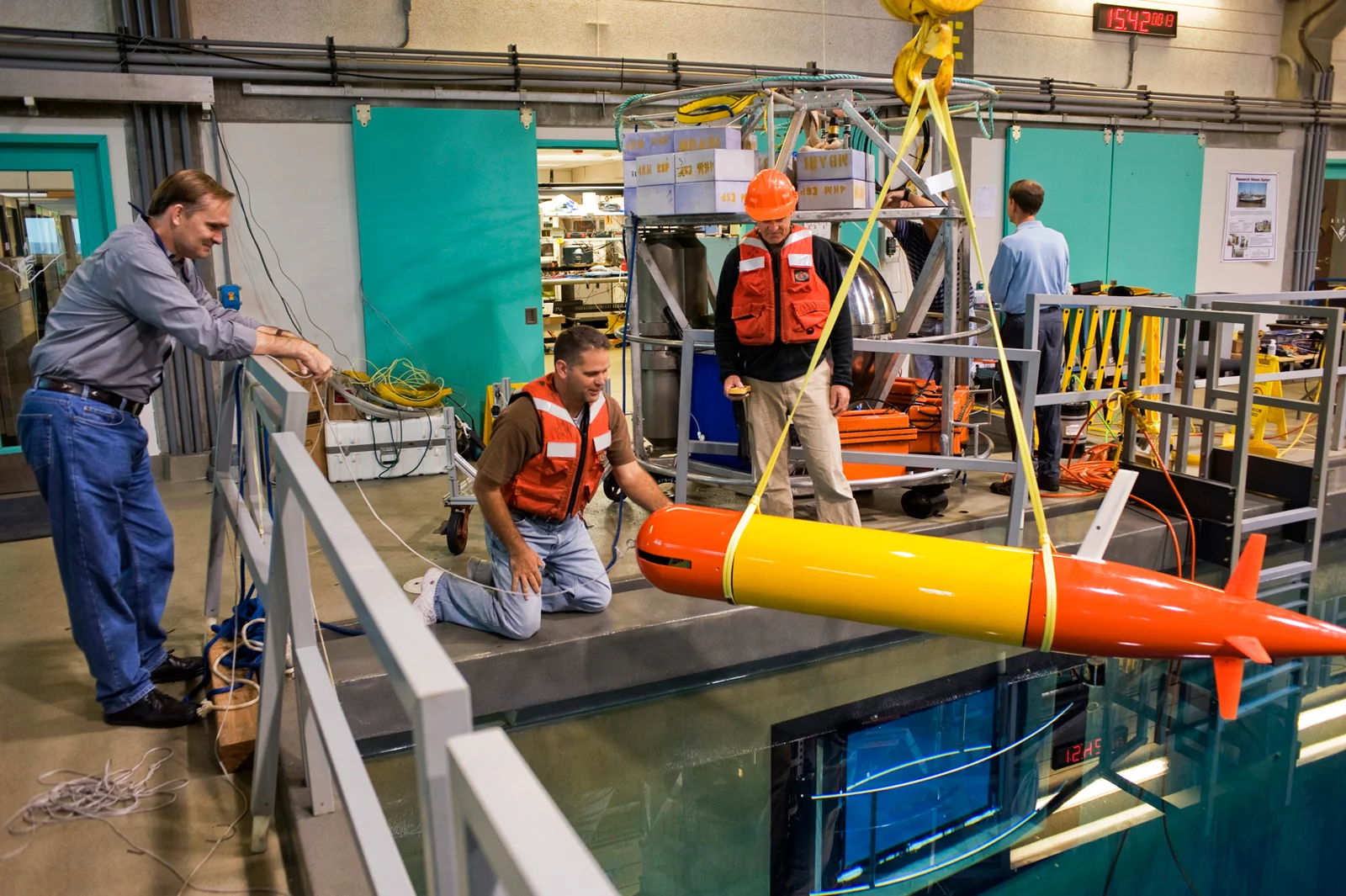Jim Bellingham, Thomas Hoover, and Bret Hobson work on the long-range AUV in the MBARI test tank (Image: Todd Walsh copyright 2010 MBARI)