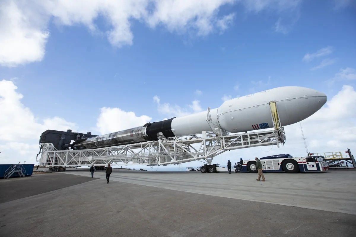 A scorched Falcon 9 is rolled out to the launchpad