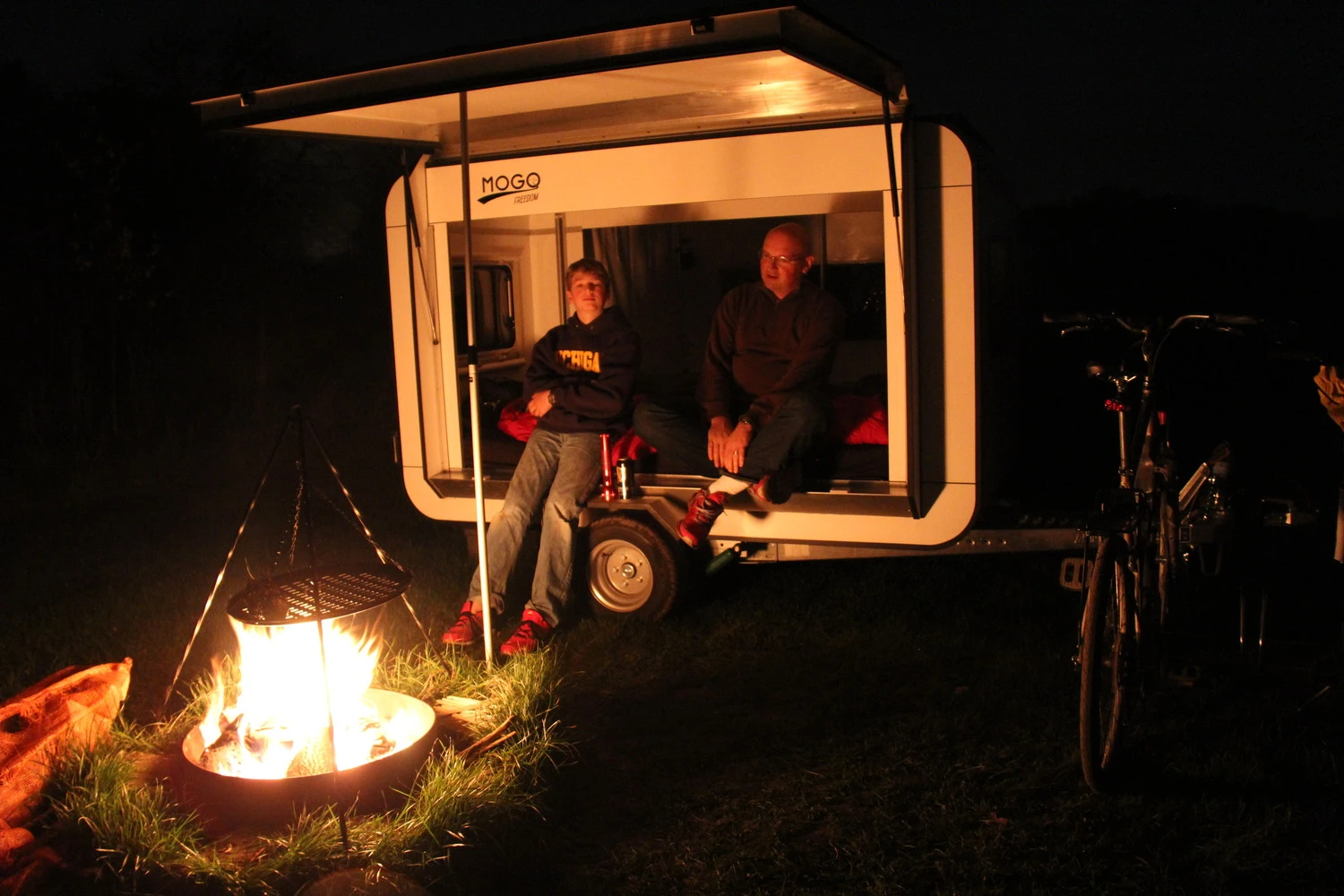 The open platform of the Mogo trailer offers a place to sit by the fire