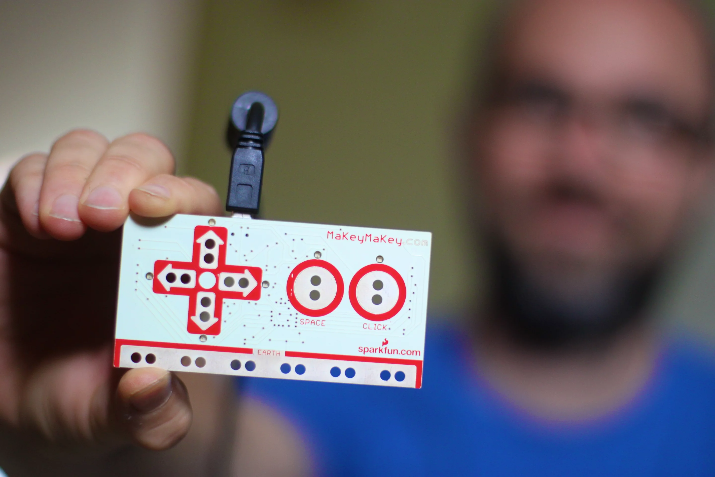 The front of the third Makey Makey prototype showing six inputs on the front of the board for attaching alligator clips, which are mapped to the arrow keys and space bar on a computer keyboard and the left button of a mouse