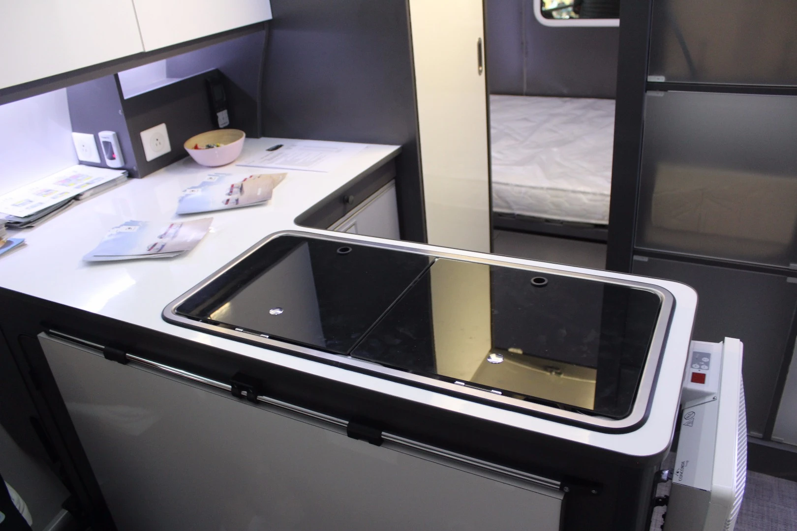 The 3X has a more compact L kitchen with dual-burner stove and a flip-up dining table on the backside of the counter