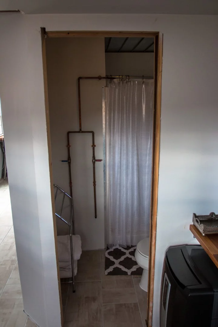 Copper piping accents along the walls for the shower.