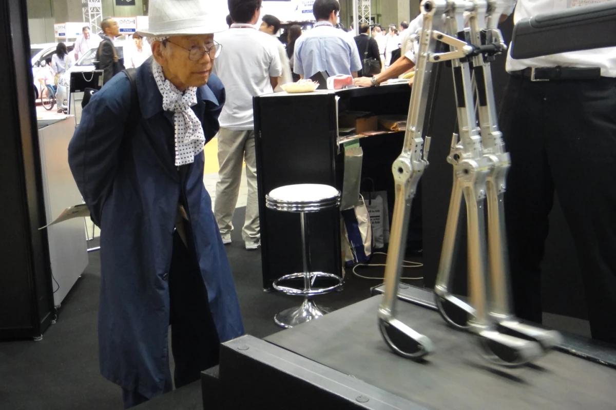 A curious observer watches the biped walk on a treadmill (Photo: Diginfo.tv)