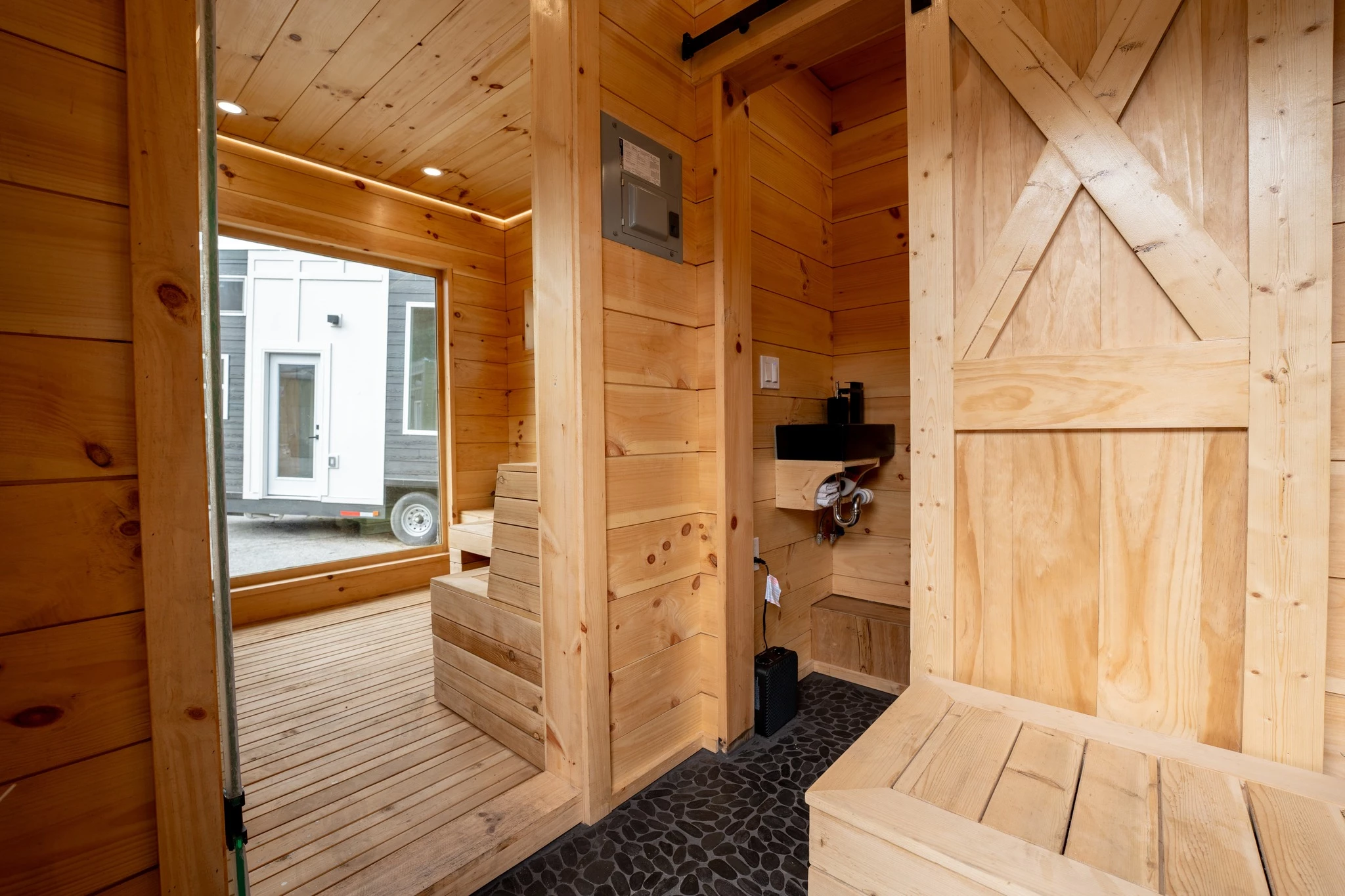 The tiny house sauna has a large window in the main sauna area to maximize natural light inside