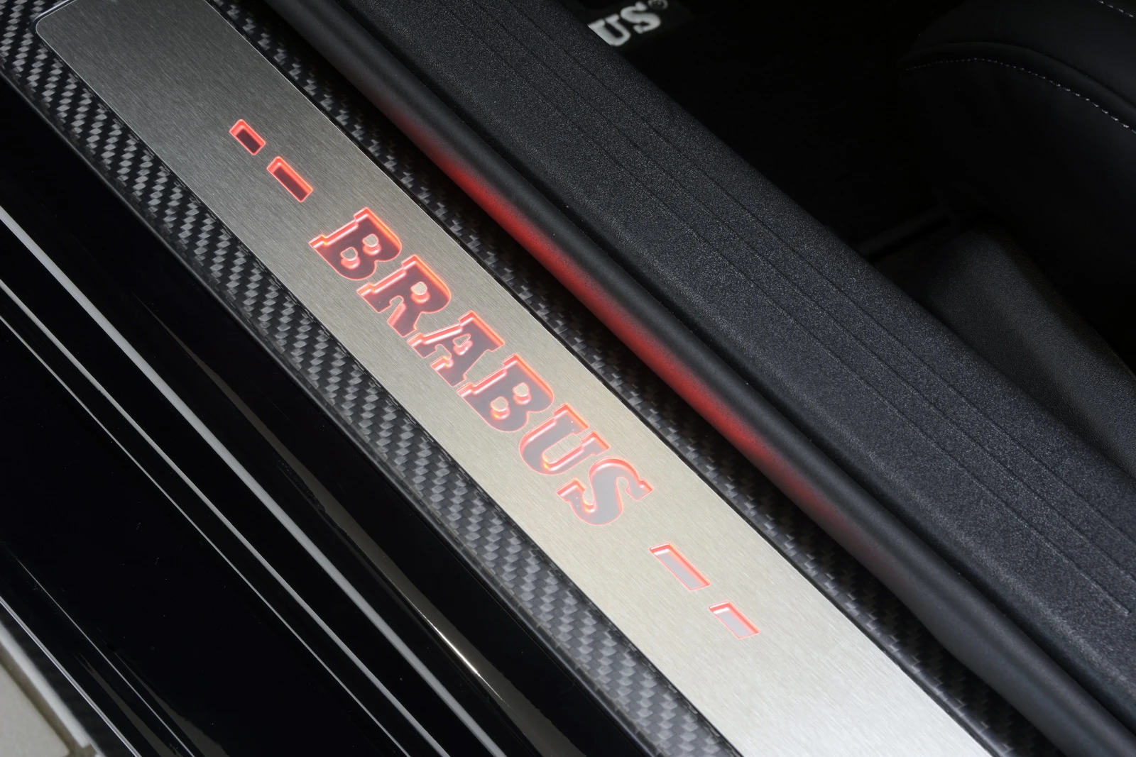 The car's carbon fiber and stainless steel kickplates are backlit
