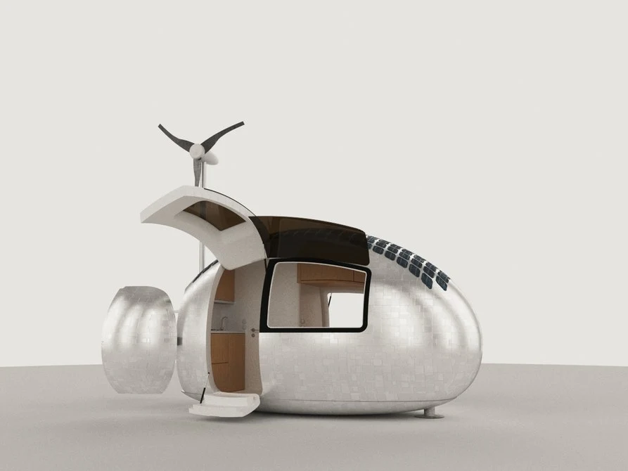 The interior of Ecocapsule includes a small seating area and workspace, a bed, toilet and shower area, and a kitchenette