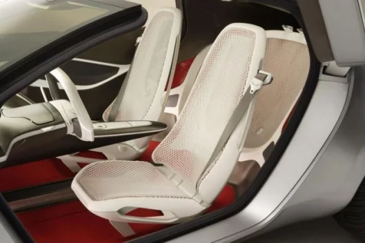 The interior of the Ford Reflex concept features lightweight inner seat frames wrapped in mesh. The white mesh fabric is offset with warm red carpeting.