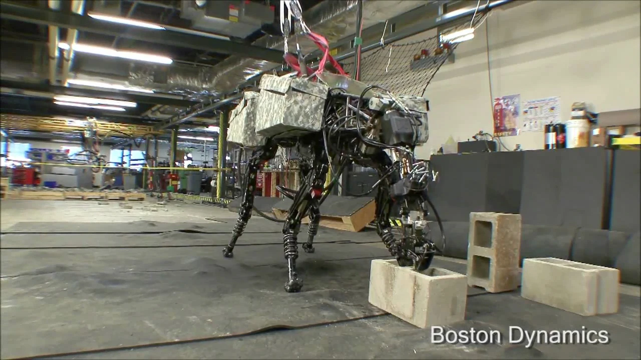 Boston Dynamics' quadruped robot BigDog grabs a cinder block from the floor using its new arm attachment