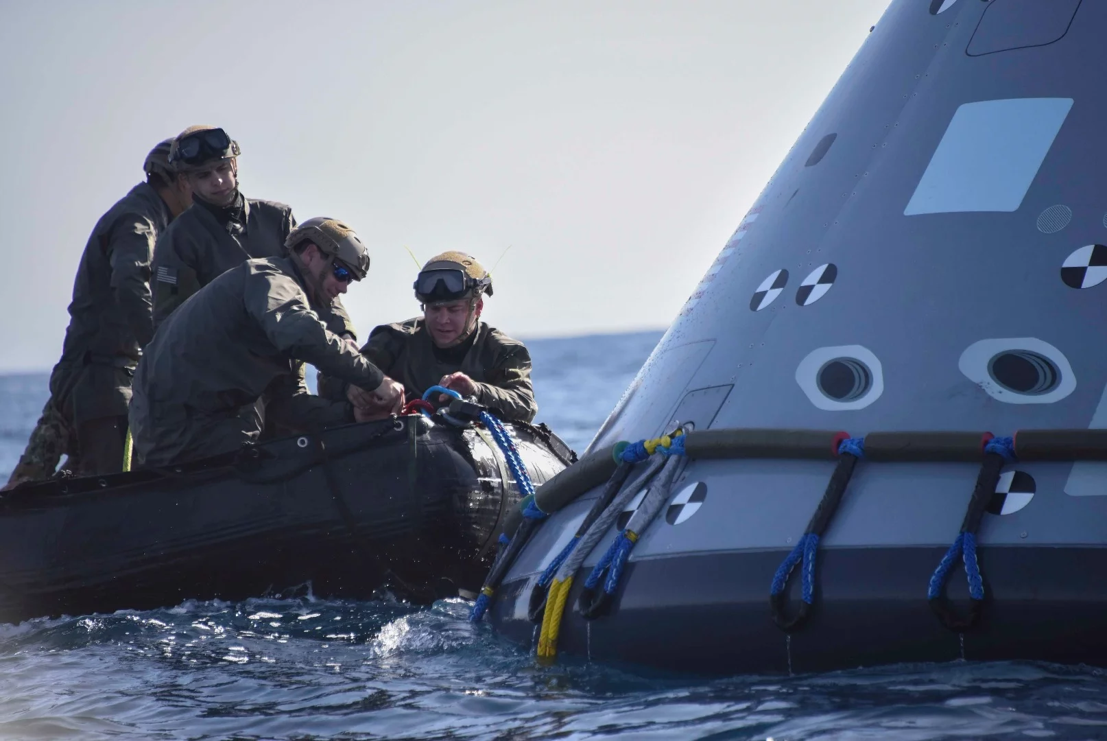 Divers attaching tow lines to the Orion test capsule