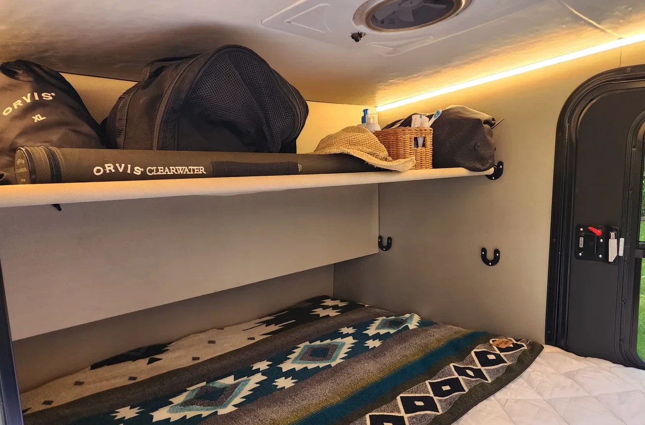 The storage shelf doubles as a small bunk for a child or pet