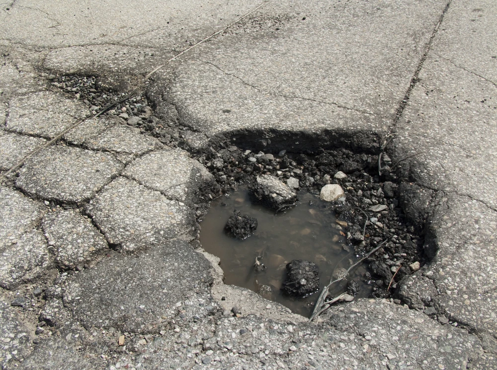 A group of students have created a unique material that they say could be sealed in bags with water, then used to temporarily fill potholes (Photo via Shutterstock)