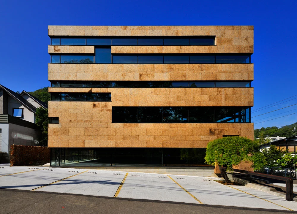 HIGO, Hokkaidō, Japan, by Nakayama Architects. A winner under the "Corporate Buildings" category of the 2018 International Architecture Awards, this three-story buildings is built on a steel frame with thin cork blocks as its exterior, which absorb sound and boost insulation