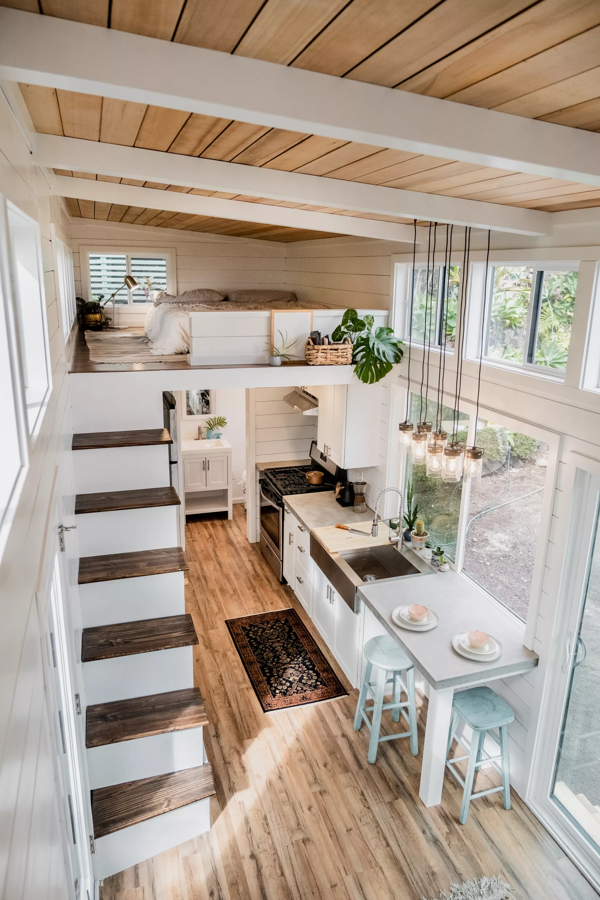 The Ohana tiny house's main bedroom is reached by storage-integrated staircase