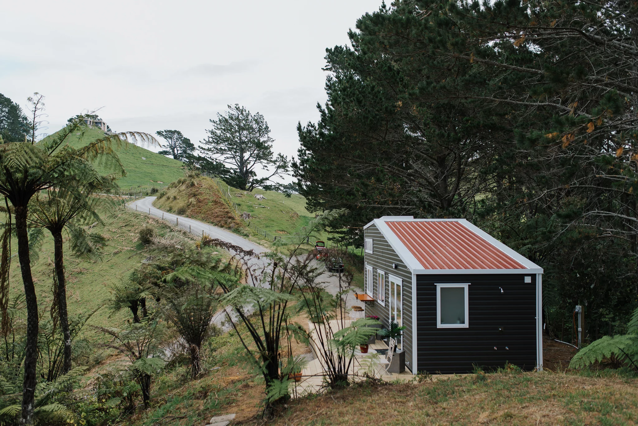 The Cherry Picker Tiny House is located in a picturesque spot overlooking the ocean in New Zealand