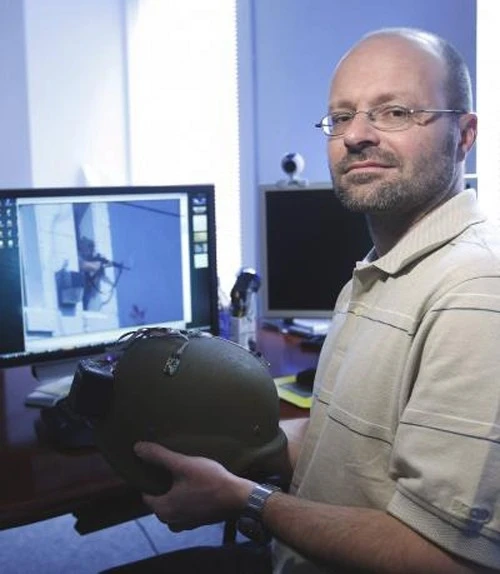 Akos Ledeczi holds a kevlar helmet with the microphones and network node attached that can turn the helmet into an accurate shooter location systemPhoto credit Steve Green, Vanderbilt University
