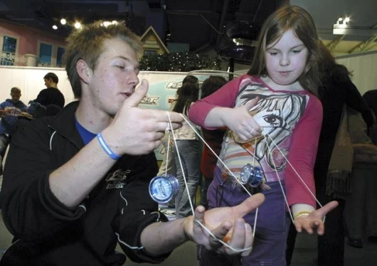 Hasbro's F.A.S.T. 201 All Stars' Patrick Mitchell teaches Beth Webb, 8, of Bracknel Berkshure in the United Kingdom how to "yo" at Toys "R" Us Times Square in New York PIC: Robin Weiner