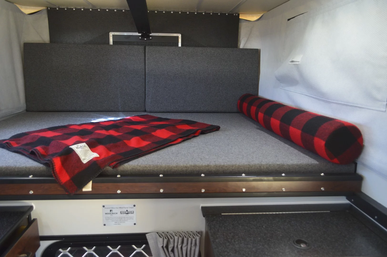 Woolrich has outfitted this special edition flat-bed pop-up camper with rustic upholstery and fabric throughout