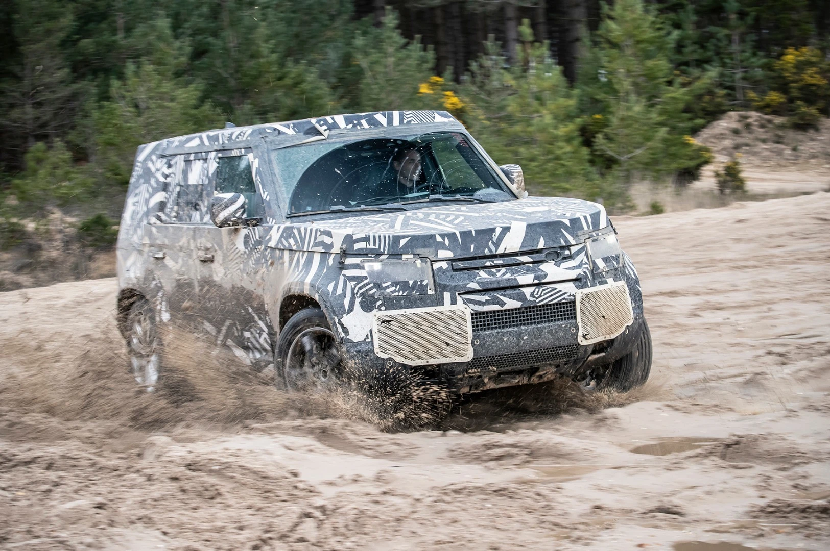The prototype Land Rover Defender battling the mud of Eastnor, UK