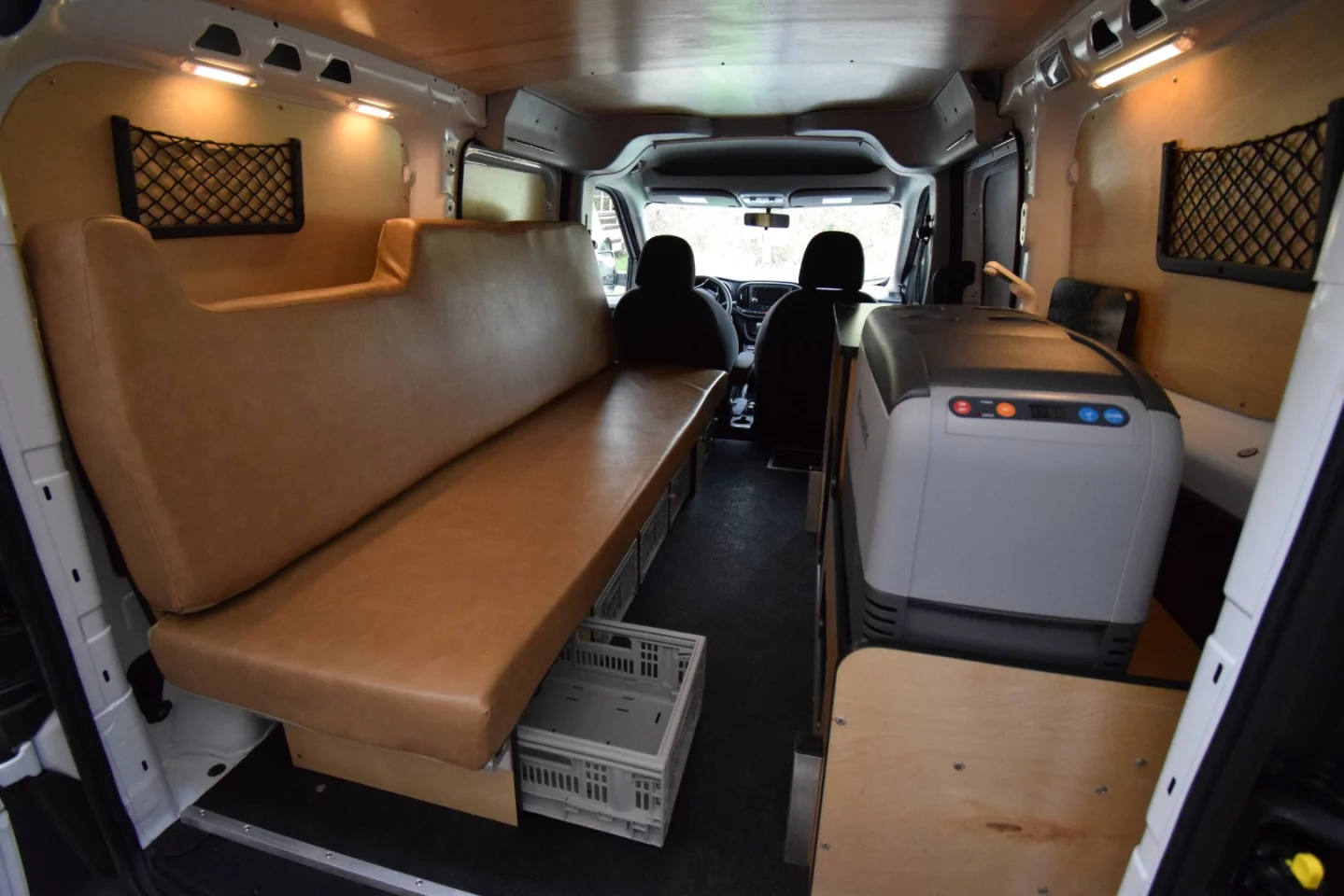 While compact, the Cascade camper van does include storage under and behind the sofa, via organizer pockets on the walls, and in the kitchen area