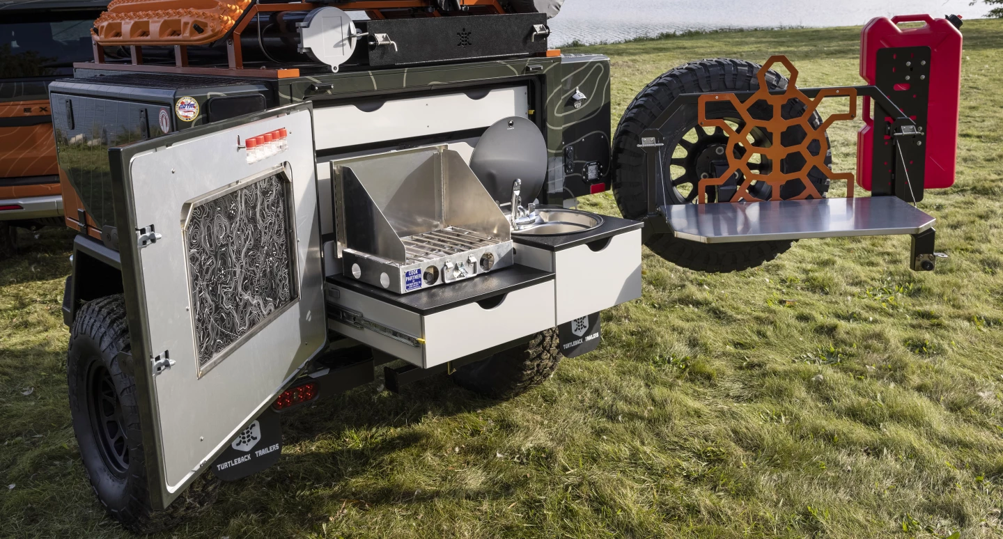Turtleback kitchen with dual-burner stove, sink and drop-down worktop