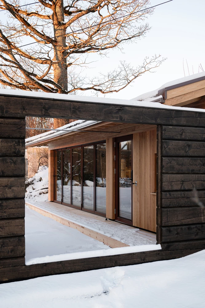 Oak cladding contrasts beautifully with the solid pine log gate